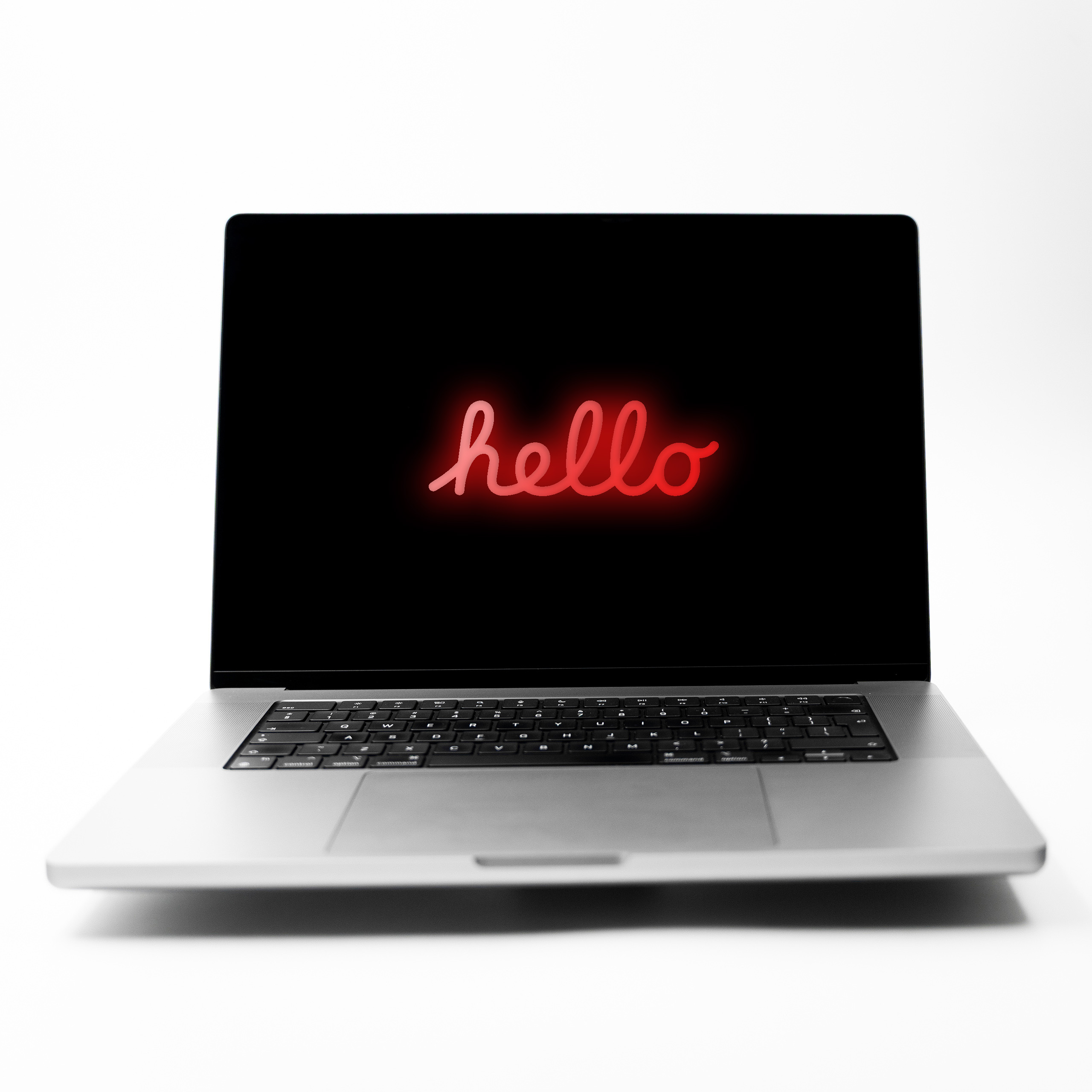 MacBook Pro 16 M1 Max Space Grey z czerwonym neonowym napisem Hello na ekranie
